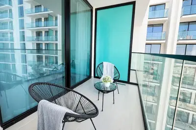a balcony with two chairs and a table on a building at Refined Luxury 1BR Binghatti Azure in Dubai