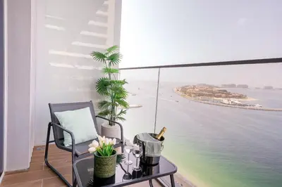 a balcony with a table and a chair and the ocean at Frank Porter - Beach Isle, Emaar Beachfront in Dubai