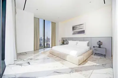a bedroom with a white bed and a large window at Stylish 4BR Penthouse with Maids Room & Modern Amenities in Dubai