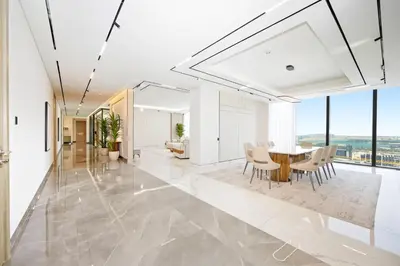 a dining room and living room with a table and chairs at Stylish 4BR Penthouse with Maids Room & Modern Amenities in Dubai