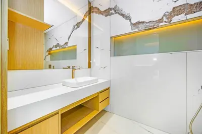 a white bathroom with a sink and a mirror at Stylish 4BR Penthouse with Maids Room & Modern Amenities in Dubai