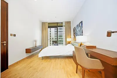 a white bedroom with a desk and a bed at Elegant 1-Bed Apartment with Premium Comforts in Dubai