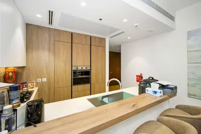 a kitchen with wooden cabinets and a counter top at Elegant 1-Bed Apartment with Premium Comforts in Dubai