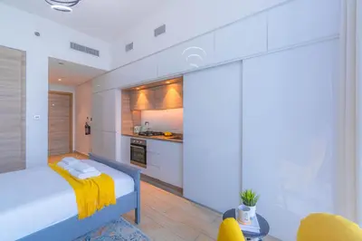 a bedroom with a bed with a yellow blanket on it at StudioOne Tower Sky-High Marina Chic, Sea Views & Designer Pool in Dubai