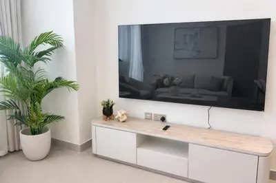 a living room with a large tv on a wall at Chic 1BR Urban Retreat Binghatti Phantom in Dubai
