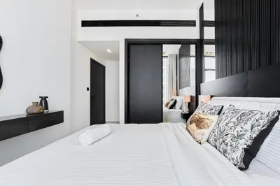 a bedroom with a large bed with white sheets and pillows at Elegant 2BR Apartment with Private Pool in JVC in Dubai