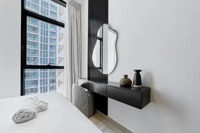 a bedroom with a mirror and a bed and a window at Elegant 2BR Apartment with Private Pool in JVC in Dubai