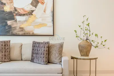 a living room with a couch and a vase on a table at Prime Waterfront Living with Partial Sea Views, Just a Short Drive from Palm Jumeirah, Marina Vista Tower 1, Emaar Beachfront by Deluxe Holiday Homes in Dubai