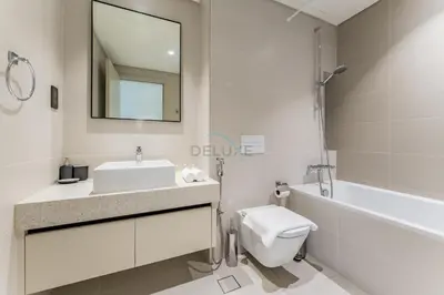 a white bathroom with a sink and a toilet at Prime Waterfront Living with Partial Sea Views, Just a Short Drive from Palm Jumeirah, Marina Vista Tower 1, Emaar Beachfront by Deluxe Holiday Homes in Dubai