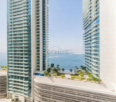 a view of the ocean between two tall buildings at Prime Waterfront Living with Partial Sea Views, Just a Short Drive from Palm Jumeirah, Marina Vista Tower 1, Emaar Beachfront by Deluxe Holiday Homes in Dubai