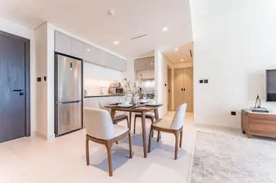 a kitchen and dining room with a table and chairs at Prime Waterfront Living with Partial Sea Views, Just a Short Drive from Palm Jumeirah, Marina Vista Tower 1, Emaar Beachfront by Deluxe Holiday Homes in Dubai