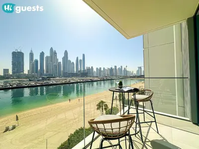 a balcony with a view of a beach and buildings at HiGuests - Beautiful Sea Facing 1BR at Emaar Beachfront in Dubai