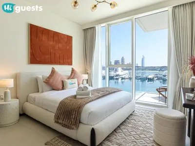 a bedroom with a large bed and a large window at HiGuests - Beautiful Sea Facing 1BR at Emaar Beachfront in Dubai