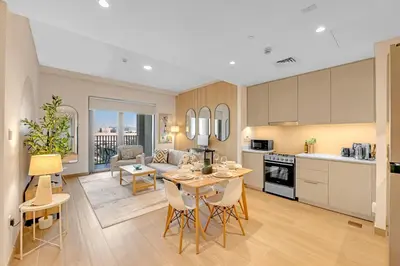 a kitchen and living room with a table and chairs at Stylish Chic 1BR with Lagoons Access - Creek Beach in Dubai
