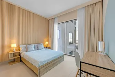 a bedroom with a bed and a large window at Stylish Chic 1BR with Lagoons Access - Creek Beach in Dubai