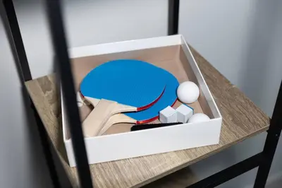 a box with a tennis ball and books on a table at Penthouse Vibes 3BR Billiard & Air Hockey in Dubai