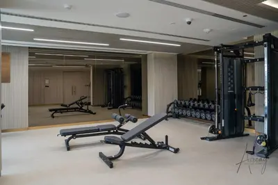a gym with several treadmills and exercise bikes at Sweet Escape 1BR in JVC Near Circle Mall in Dubai