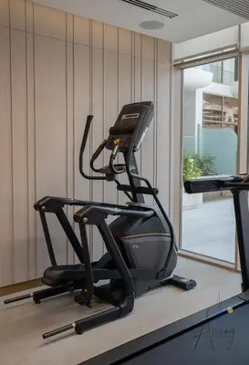 a gym with a treadmill and a window at Sweet Escape 1BR in JVC Near Circle Mall in Dubai