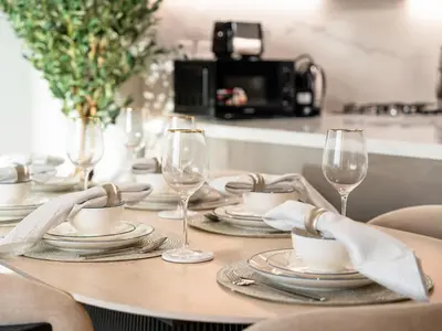a table with plates and wine glasses on it at Stunning 2BR at Azizi Amber Sleeps 5 in Dubai