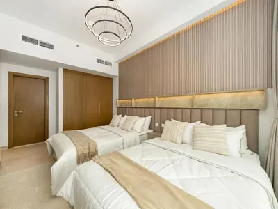 a bedroom with two beds and a wall at Stunning 2BR at Azizi Amber Sleeps 5 in Dubai