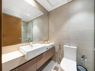 a bathroom with a sink and a toilet and a mirror at Stunning 2BR at Azizi Amber Sleeps 5 in Dubai