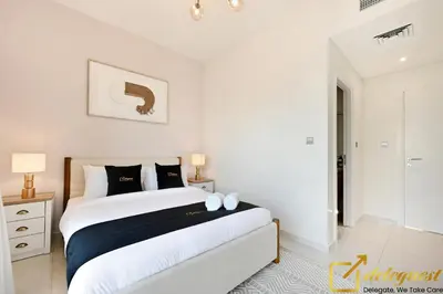 a bedroom with a large bed with black and white pillows at Signature 3BR Maid Villa DH2 by Deleguest in Dubai