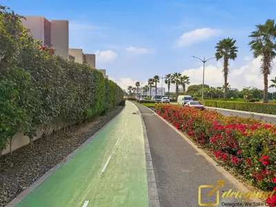 a road with flowers and cars on a street at Signature 3BR Maid Villa DH2 by Deleguest in Dubai