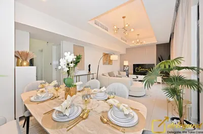 a dining room and living room with a table and chairs at Signature 3BR Maid Villa DH2 by Deleguest in Dubai
