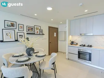 a kitchen and dining room with a table and chairs at HiGuests - Sunlit 1 BR Escape with Emaar Beachfront Access in Dubai