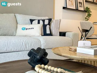 a living room with a couch and a table at HiGuests - Sunlit 1 BR Escape with Emaar Beachfront Access in Dubai