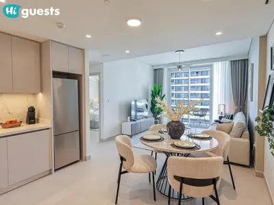 a kitchen and living room with a table and chairs at HiGuests - Sunlit 1 BR Escape with Emaar Beachfront Access in Dubai