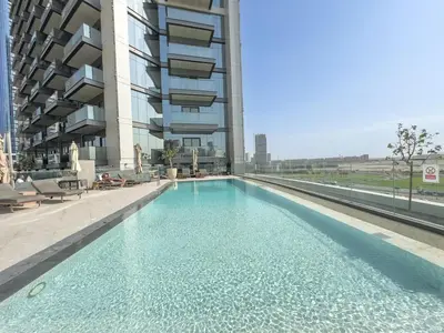 a swimming pool in front of a building at Boutique 1BHK at Nobles Tower By Czechin in Dubai