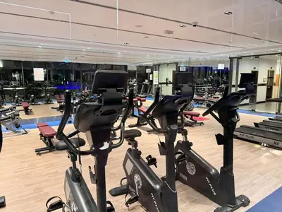 a gym with a bunch of exercise bikes in it at Pool view Studio with balcony in Arjan in Dubai