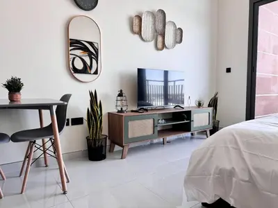 a bedroom with a desk and a tv and a bed at Pool view Studio with balcony in Arjan in Dubai