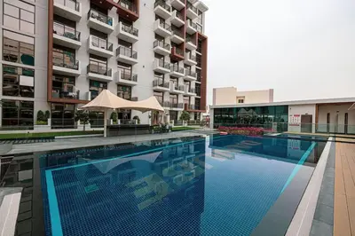 a large swimming pool in front of a building at Pool view Studio with balcony in Arjan in Dubai