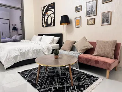a living room with a couch and a bed at Pool view Studio with balcony in Arjan in Dubai