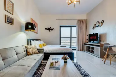 a living room with a couch and a bed at Studio in Liwan for long stays 1005 in Dubai