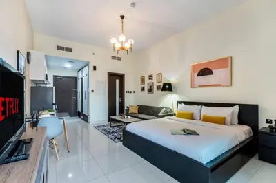 a bedroom with a large bed and a living room at Studio in Liwan for long stays 1005 in Dubai