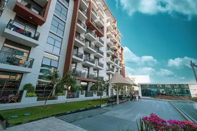 an apartment building with a patio and an umbrella at New studio in Arjan ideal for long stays in Dubai