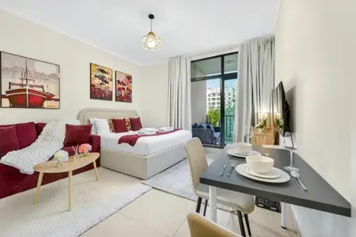 a living room with a couch and a table at Serene Studio at The Links Canal in Dubai