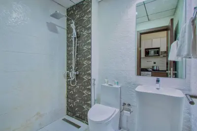 a bathroom with a shower and a toilet and a sink at Modern Studio in Barsha south with balcony in Dubai