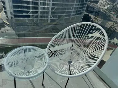 two white chairs sitting on top of a window at Skyz by Danube Studio Apartment in Arjan , Pool, Gym & Near Miracle Garden in Dubai