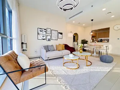 a living room with a couch and a table at Downtown Luxury 1BR with Pool, Gym, Fast WiFi and 8 Min Walk to Burj Khalifa in Dubai