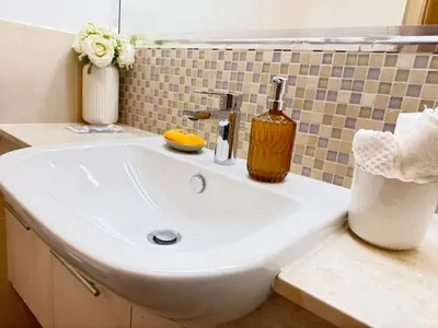 a white sink in a bathroom with a mirror at Downtown Luxury 1BR with Pool, Gym, Fast WiFi and 8 Min Walk to Burj Khalifa in Dubai