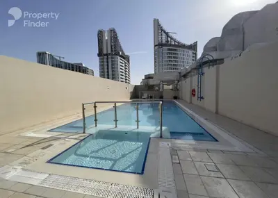 a swimming pool on top of a building with tall buildings at Large 1-bedroom by the canal, close to downtown in Dubai