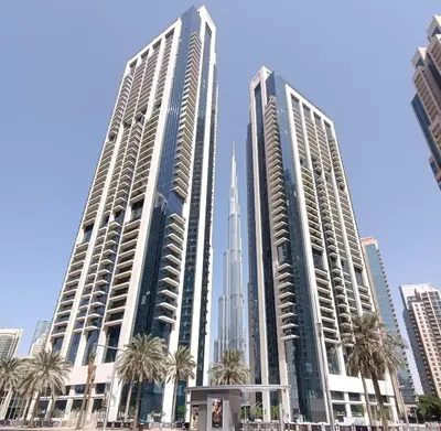 two tall buildings in a city with palm trees at Burj khalifa in Dubai