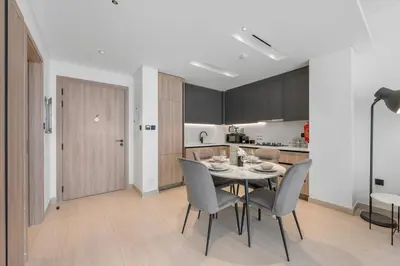 a kitchen and dining room with a table and chairs at Modern Apartment w/ Balcony & Rooftop Amenities in Dubai