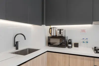 a kitchen with a sink and a microwave at Modern Apartment w/ Balcony & Rooftop Amenities in Dubai