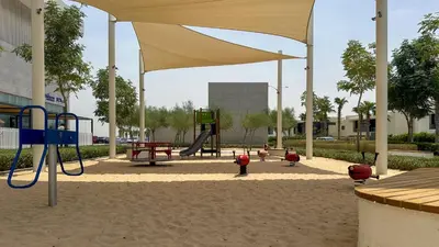 a playground with children playing in a sandbox at Maison Privee - Refined Studio with Top Facilities in Damac Hills in Dubai