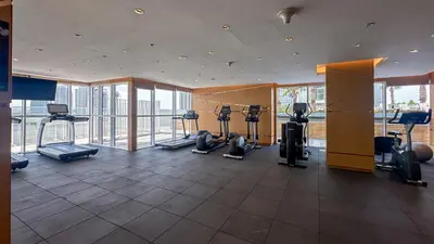a gym with treadmills and exercise equipment in a building at Maison Privee - Refined Studio with Top Facilities in Damac Hills in Dubai